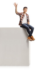 Wall Mural - Guy sitting on a high wall and waving at camera