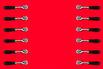 Wall Mural - Frame from ratchet for end heads isolated on red background with copy space. Shop banner with construction tools. New Year or Christmas festive backdrop. Useful instrument for repair auto or house