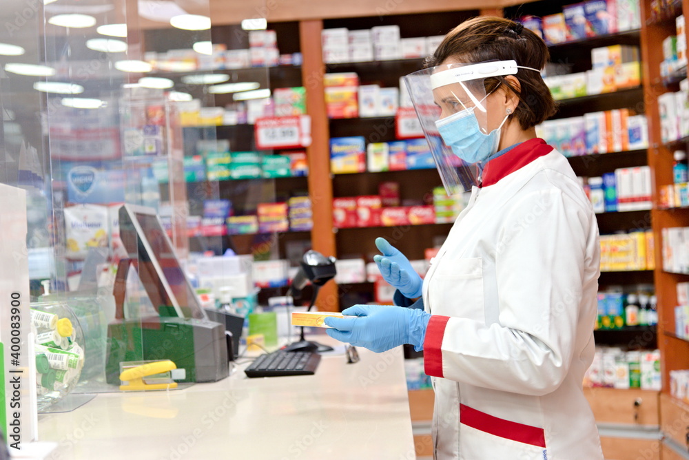 Pharmacist dispensing drugs in a pharmacy.
 - obrazy, fototapety, plakaty 