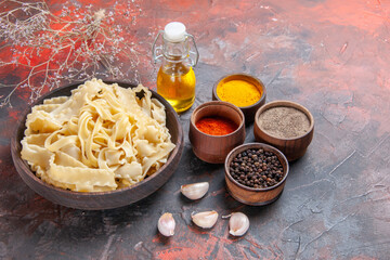 front view sliced raw dough with seasonings on dark background dark dough pasta food