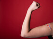 © Mat Hayward - Female arm flexing bicep and making a fist wearing a bandage after receiving a Covid-19 Coronavirus vaccine injection