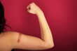 © Mat Hayward - Female arm flexing bicep and making a fist wearing a bandage after receiving a Covid-19 Coronavirus vaccine injection