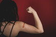 © Mat Hayward - Female arm flexing bicep and making a fist wearing a bandage after receiving a Covid-19 Coronavirus vaccine injection