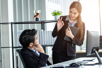 Wall Mural - Stressed businessman at work with businesswoman partners helping to positive recommendations and encourage each other working with computer ideas at meeting in office background.