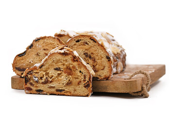 Wall Mural - German Stollen cake, a fruit bread with nuts, spices, and dried or candied fruits with powdered sugar traditionally served during Christmas time on cutting board isolated on white background