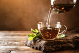 Fototapeta Niebo - Cup of hot tea with fresh mint leaves