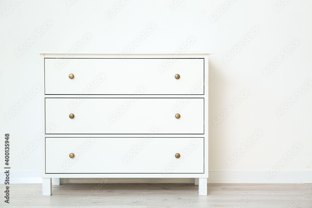 Modern chest of drawers near white wall