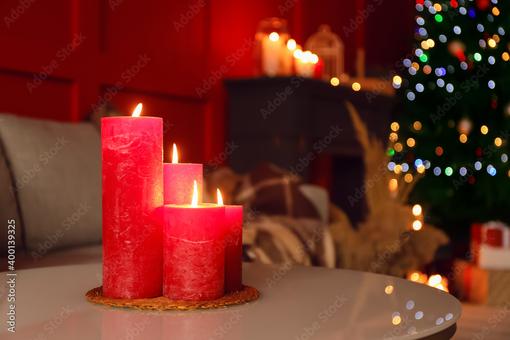Burning candles in living room decorated for Christmas