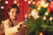 © Pixel-Shot - Cute little girl decorating Christmas tree at home
