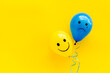 Positive and negative emotions background. Sad and happy faces on ballons