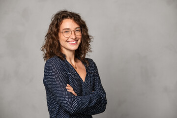 Fototapete - Successful smiling woman wearing eyeglasses on grey wall