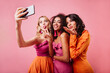 © Look! - Latin happy girl sending air kiss. Charming ladies making selfie on pink background.