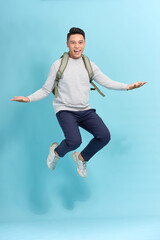 Wall Mural - travel, tourism and people concept - happy smiling young man with backpack jumping in air over grey background