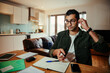 © Prins Productions - Mixed race businessman wearing spectacles working on laptop writing on notepad working from home office
