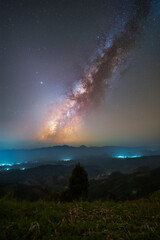 Wall Mural - Vertical milkyway rise over the hill in Tak province, Thailand