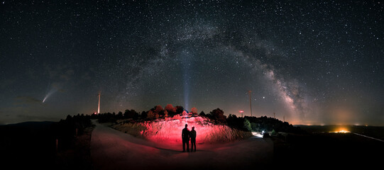 Wall Mural - Comet Nowise. A loving couple observes the Milky Way and Comet Neowise as it orbits the solar system. Night landscape, a panoramic view of the Milky Way and Comet Nowise in July 2020. 