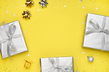 Gift Boxes, Gray Decorations On Yellow Background And Place To The Text. Trendy Color. Christmas, New Year Concept. Top View. Copy Space.