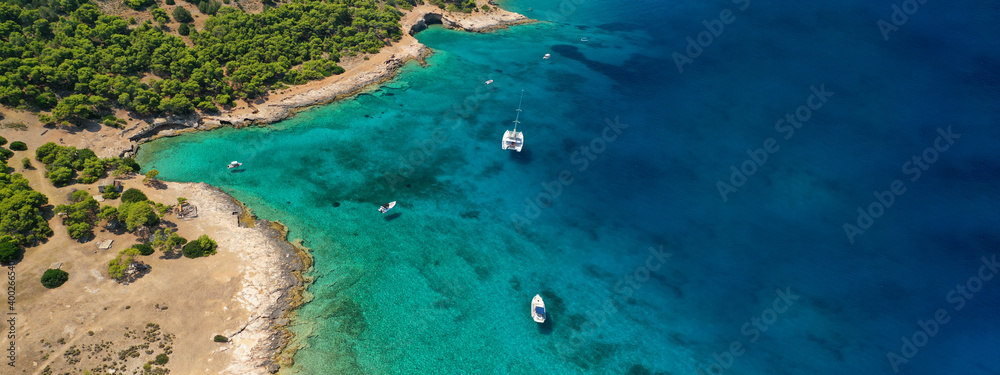 Aerial drone ultra wide photo of exotic bay of Moni island visited by yachts and sail boats, Aegina island, Saronic gulf, Greece - obrazy, fototapety, plakaty 