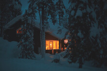 A Night View Of Cozy Wooden Scandinavian Cabin Cottage Chalet House Covered In Snow Near Ski Resort In Winter With The Lights Turn On, Evening Picture