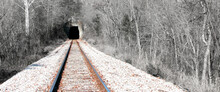 Railroad Tracks Leading Into A Dark Black Tunnel Of Unknown. Parallel Tracks Perspective Vanishing Point.