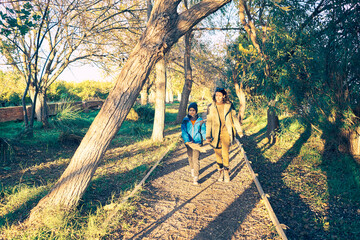 A mother and her son walking in the park at sunset. Happy family concept