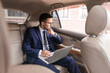 © Pixel-Shot - Successful businessman with laptop in modern car