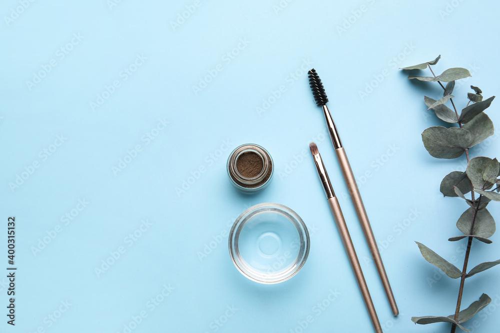 Natural henna and brushes on color background