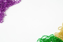 Mardi Gras Background, Border On White With Purple Gold Green Beads And Copy Space