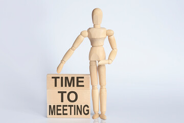 Poster - Wooden man shows with a hand text TIME TO MEETING concept on the wooden block
