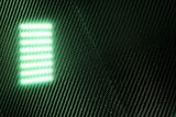 Fototapeta Sawanna - green light reflecting off carbon fiber sheets
