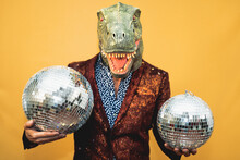 Fashion Senior Man Wearing T-rex Dinosaur Mask While Celebrating Carnival Holidays - Surreal Masking Concept