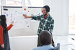 © Yakobchuk Olena - Smiling multiracial student man standing near flip chart for drawing graphic