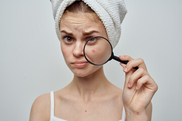 pretty woman with towel on head skin care magnifier near face