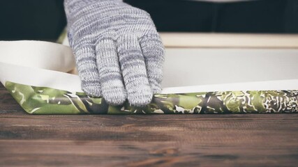 man stretching the canvas on a stretcher. printing photos on canvas.