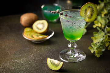 Cold cocktail kiwi drink in a glass with fresh fruits on black background