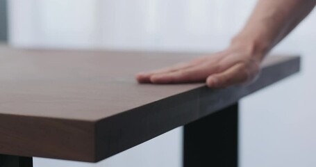 Poster - Slow motion of man hand checking toned walnut table surface before applying finish