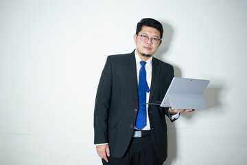 Happy young business man working on a laptop, isolated on white background