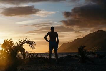 Wall Mural - Silhouette of man over sunset on the sea background