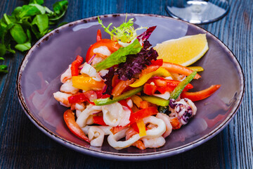 Wall Mural - Salad with squid, bell pepper and onion on gray plate