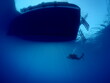 scuba divers ascending descending on the line of boat rope underwater blue