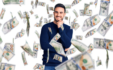 Young handsome man wearing casual clothes looking confident at the camera with smile with crossed arms and hand raised on chin. thinking positive.