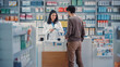 Pharmacy Drugstore Checkout Cashier Counter: Beautiful Female Pharmacist Scans Barcode and Handsome Young Man Talks to a Cashier and Pays for the Health Care Products at the Checkout Counter.
