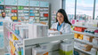 © Gorodenkoff - Pharmacy Drugstore: Portrait of Beautiful Latina Pharmacist Wearing White Coat Arranges Medicine, Drugs, Vitamins on a Shelf. Professional Pharmacist in Pharma Store Shelves with Health Care Products
