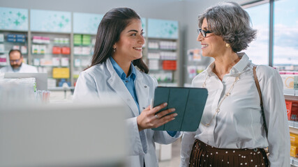 Wall Mural - Pharmacy Drugstore: Senior Woman Chooses to Buy Medicins. Professional, Helpful Pharmacist Uses Digital Tablet Computer and Advicing Customer Best Option. Modern Pharma Store Health Care Products