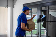 © ake - Caucasian young delivery man with parcel boxes to customer at apartment condominium elevator door. social distancing new normal concept.