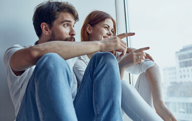 man and woman sitting on the windowsill technology communication interior window joy