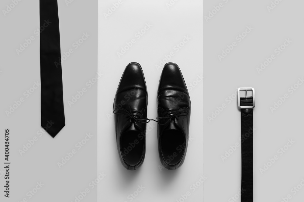 Stylish male shoes and accessories on light background