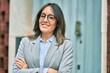 © Krakenimages.com - Young hispanic businesswoman with arms crossed smiling happy at the city