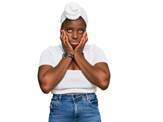 Poster - Young african woman with turban wearing hair turban over isolated background tired hands covering face, depression and sadness, upset and irritated for problem