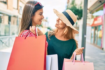 Wall Mural - Beautiful hispanic mother and daughter smiling happy and shopping at the city.